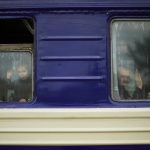 
              A child and a man, fleeing from heavy shelling, wave to the photographer before departing in an evacuation train at Pokrovsk train station, in Pokrovsk, eastern Ukraine, Sunday, May 22, 2022. Civilians fleeing areas near the eastern front in the war in Ukraine Sunday described scenes of devastation as their towns and villages came under sustained attack from Russian forces. (AP Photo/Francisco Seco)
            