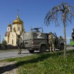 
              Russian servicemen guard an area in front of an Orthodox church in Berdyansk, in territory under the government of the Donetsk People's Republic, eastern Ukraine, Saturday, April 30, 2022. (AP Photo)
            