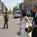 
              A Russian serviceman guards an area during a wedding ceremony of several pairs in the center of Berdyansk, in territory under the government of the Donetsk People's Republic, eastern Ukraine, Saturday, April 30, 2022. This photo was taken during a trip organized by the Russian Ministry of Defense. (AP Photo)
            