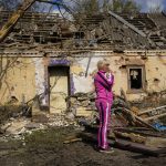 
              Iryna Martsyniuk, 50, stands next to her house, heavily damaged after a Russian bombing in Velyka Kostromka village, Ukraine, Thursday, May 19, 2022. Martsyniuk and her three young children were at home when the attack occurred in the village, a few kilometres from the front lines, but they all survived unharmed. (AP Photo/Francisco Seco)
            