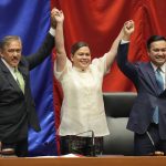 
              Vice-president-elect Sara Duterte, center, raises hands with Senate President Vicente Sotto III, left, and House Speaker Lord Allan Velasco during her proclamation at the House of Representatives, Quezon City, Philippines on Wednesday, May 25, 2022. Sara is the daughter of outgoing president Rodrigo Duterte. (AP Photo/Aaron Favila)
            