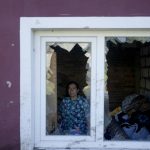 
              Nastasia Vladimirovna poses for a picture at her home destroyed by attacks in Mostyshche, on the outskirts Kyiv, Ukraine, Monday, June 6, 2022. Vladimirovna lived there with 18 members of her family but now she is staying with her husband on her neighbor's home. (AP Photo/Natacha Pisarenko)
            