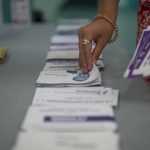 
              A woman selects ballots in the first round of the French parliamentary election, Sunday, June 12, 2022 in Marseille, southern France. Voters are choosing lawmakers as President Emmanuel Macron seeks to secure his majority while under growing threat from a leftist coalition. (AP Photo/Daniel Cole)
            