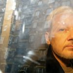 FILE - Buildings are reflected in the window as WikiLeaks founder Julian Assange is taken from court, where he appeared on charges of jumping British bail seven years ago, in London, Wednesday May 1, 2019. The British government on Friday, June 17, 2022 ordered the extradition of WikiLeaks founder Julian Assange to the United States to face spying charges. He is likely to appeal. (AP Photo/Matt Dunham, File)