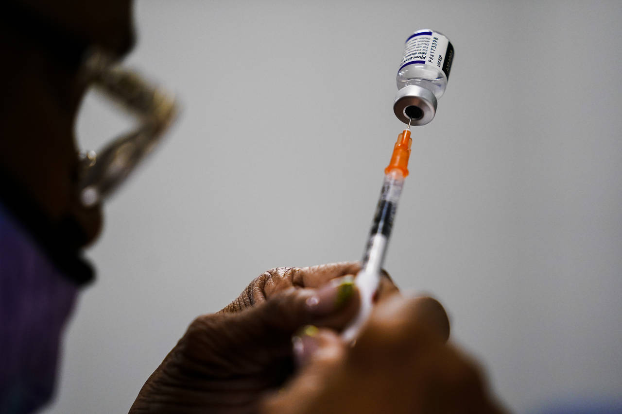 FILE - A syringe is prepared with the Pfizer COVID-19 vaccine at a vaccination clinic at the Keysto...