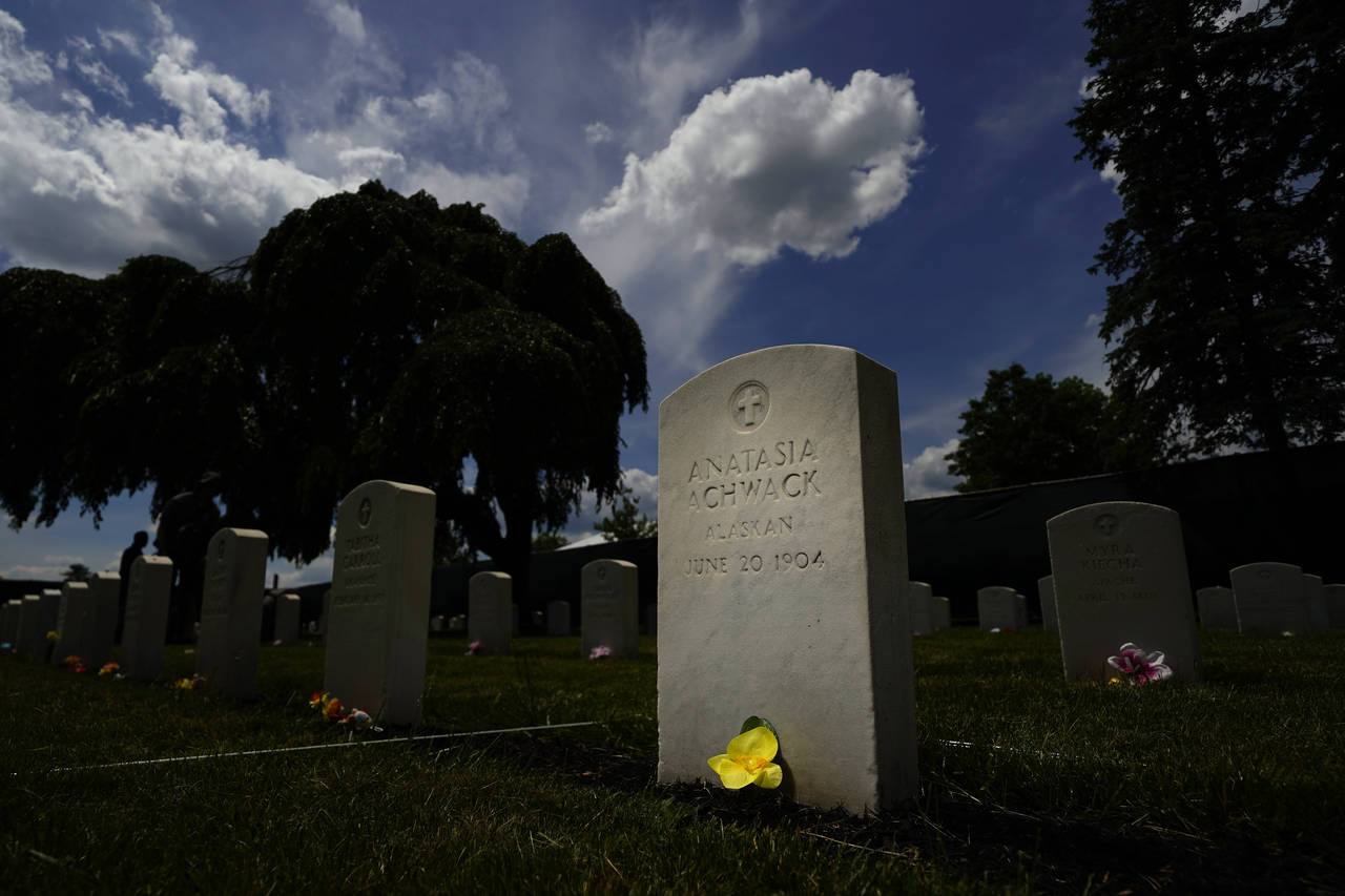 A flower sits at the base of headstone at the cemetery of the U.S. Army's Carlisle Barracks, Friday...