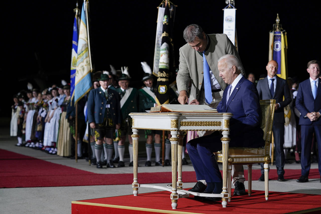 President Joe Biden signs a guest book after arriving as Bavarian Prime Minister Markus Soeder stan...