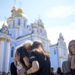 
              Women hug each other during the memorial service of activist and soldier Roman Ratushnyi in Kyiv, Ukraine, Saturday, June 18, 2022. Ratushnyi died in a battle near Izyum, where Russian and Ukrainian troops are fighting for control the area.(AP Photo/Natacha Pisarenko)
            