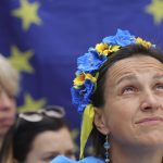 
              A protestor wears a flower headband in the Ukraine colors as she participates in a demonstration in support of Ukraine outside of an EU summit in Brussels, Thursday, June 23, 2022. European Union leaders are expected to approve Thursday a proposal to grant Ukraine a EU candidate status, a first step on the long toward membership. (AP Photo/Olivier Matthys)
            
