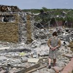 
              An elderly woman walks next to a building damaged by an overnight missile strike in Sloviansk, Ukraine, Wednesday, June 1, 2022. (AP Photo/Andriy Andriyenko)
            