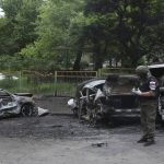 
              A member of Russian Investigative Committee prepares to use a drone at the scene of burned vehicles after the shelling in the Petrovsky district of Donetsk, on the territory which is under the Government of the Donetsk People's Republic control, eastern Ukraine, Sunday, June 5, 2022. The Russian State news agency TASS said five civilians were killed and 20 were injured Saturday as a result of multiple explosions close to the city of Donetsk. (AP Photo)
            