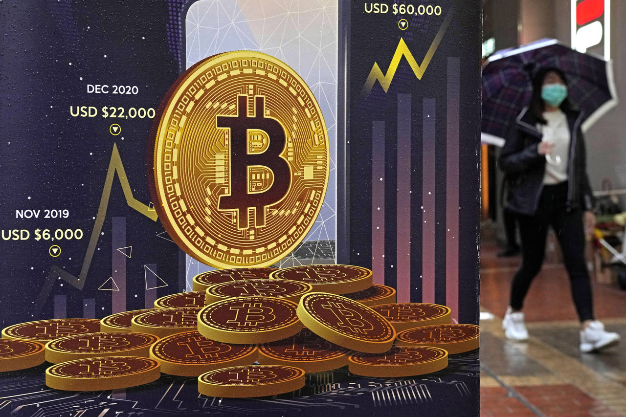 FILE - An advertisement for Bitcoin cryptocurrency is displayed on a street in Hong Kong on Feb. 17...