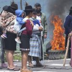 
              Women stand next to a burning barricade as they block a highway during a second day-national demonstration against the government of Guillermo Lasso called mainly by indigenous organizations, in Santa Rosa, Ecuador, Tuesday, June 14, 2022. (AP Photo/Dolores Ochoa)
            