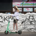 
              A girl rides a scooter past sandbags to protect against Russian shelling in central Kyiv, Ukraine, Tuesday, June 7, 2022. (AP Photo/Efrem Lukatsky)
            