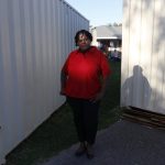 
              Lydia Larce stands in front of construction containers outside her home in Lake Charles, La., on Thursday, March 31, 2022. More than a year after Hurricane Laura wreaked havoc on area, Larce is living in a FEMA trailer behind her home. She fears that emissions from the oil and gas industry — including the growing number of liquid natural gas export facilities along the Gulf Coast — will worsen global warming. "Our politicians in D.C., they're not taking it seriously," she says. (AP Photo/Martha Irvine)
            