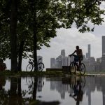 
              Bicyclists and sunbathers find some shade while temperatures in the 90s persist along the lakefront Wednesday, June 15, 2022, near North Avenue Beach in Chicago. (Brian Cassella/Chicago Tribune via AP)
            