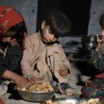 
              Afghan children eat in a makeshift shelter after an earthquake in Gayan district in Paktika province, Afghanistan, Saturday, June 25, 2022. A powerful earthquake struck a rugged, mountainous region of eastern Afghanistan early Wednesday, flattening stone and mud-brick homes in the country's deadliest quake in two decades, the state-run news agency reported. (AP Photo/Ebrahim Nooroozi)
            
