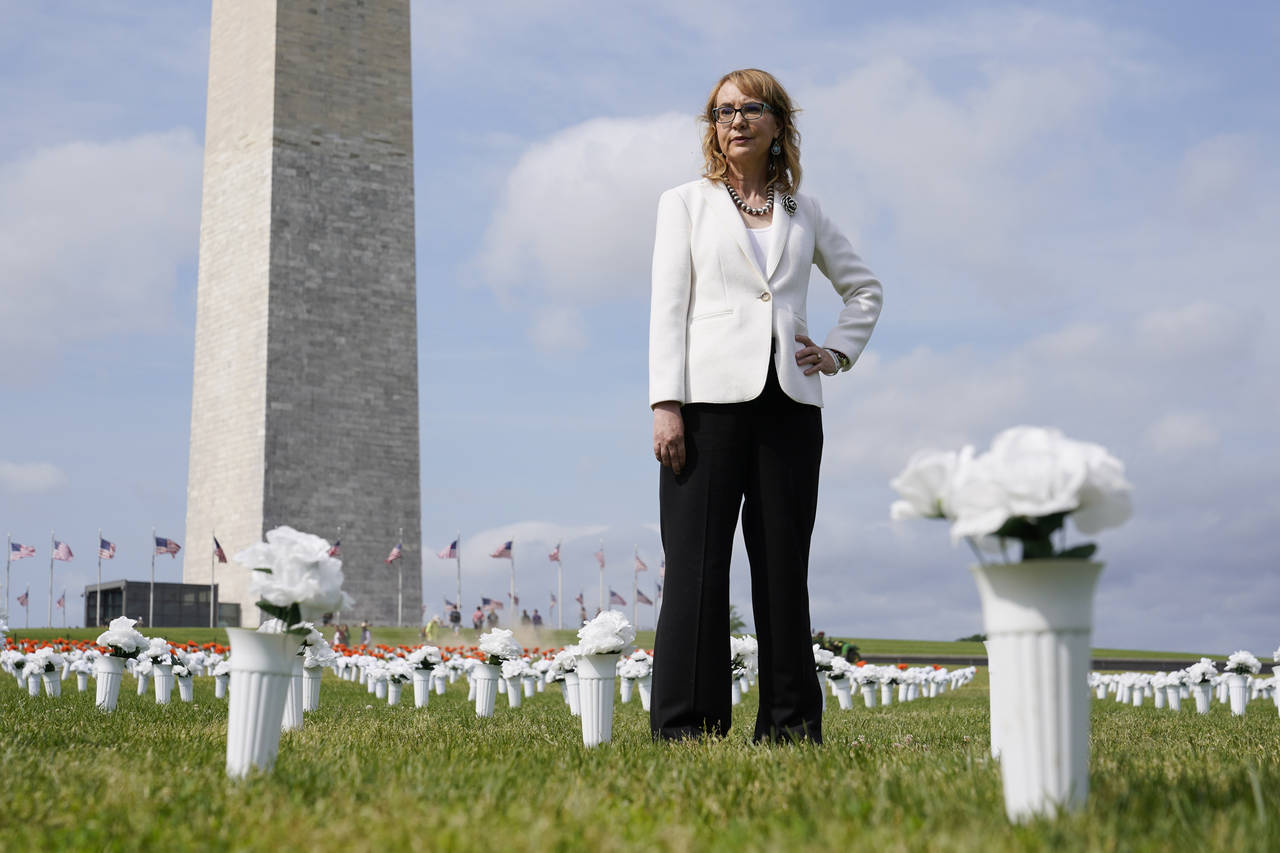 Former congresswoman and gun violence survivor Gabby Giffords stands among vases of flowers that ma...