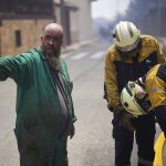 
              A neighbour helps firefighters in San Martin de Unx in northern Spain, Sunday, June 19, 2022. Firefighters in Spain are struggling to contain wildfires in several parts of the country which as been suffering an unusual heat wave for this time of the year. (AP Photo/Miguel Oses)
            