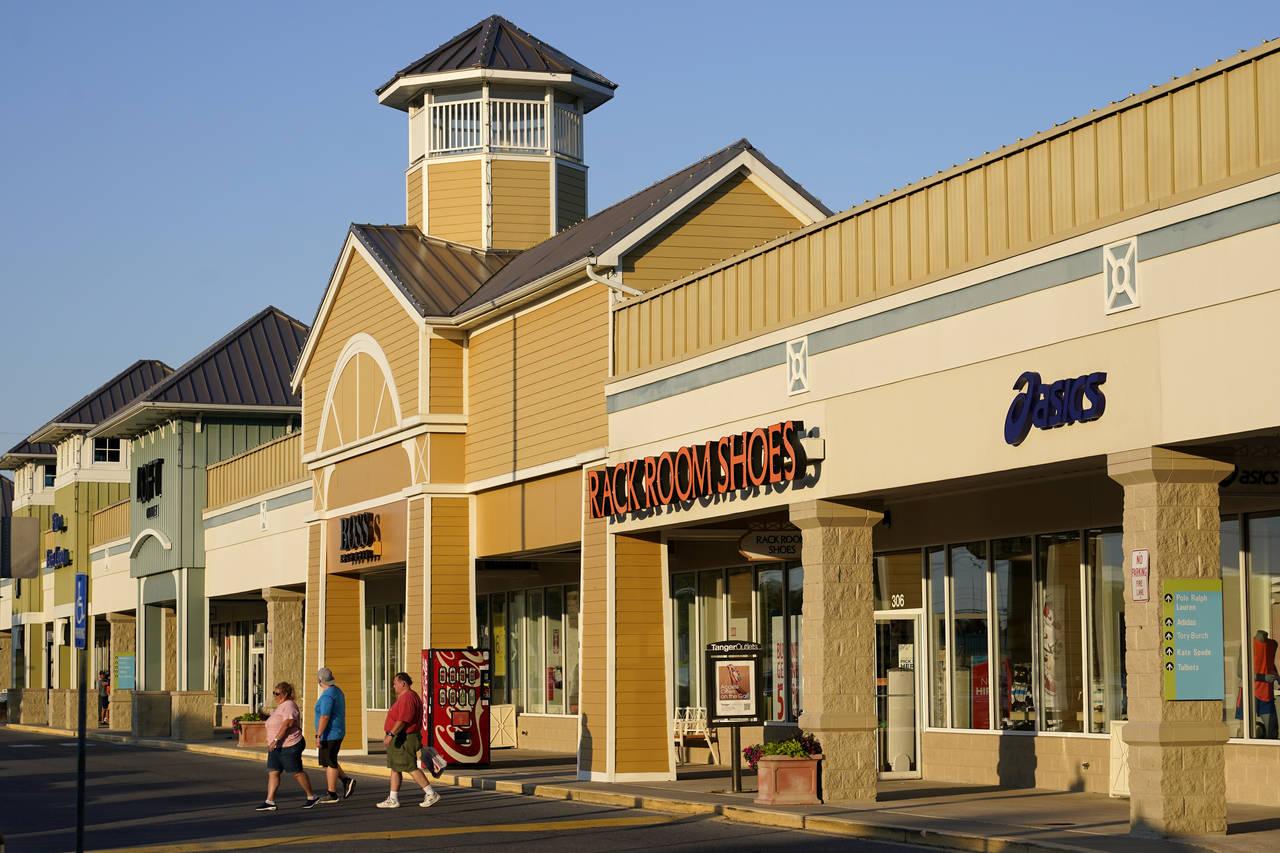 Shoppers walk outside an outlet mall in Rehoboth Beach, Del., Saturday, June 4, 2022. President Joe...
