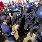 
              An organiser tries to calm sides during scuffles between police and protestors at a demonstration ahead of a G7 summit in Munich, Germany, Saturday, June 25, 2022. The G7 Summit will take place at Castle Elmau near Garmisch-Partenkirchen from June 26 through June 28, 2022. (AP Photo/Matthias Schrader)
            