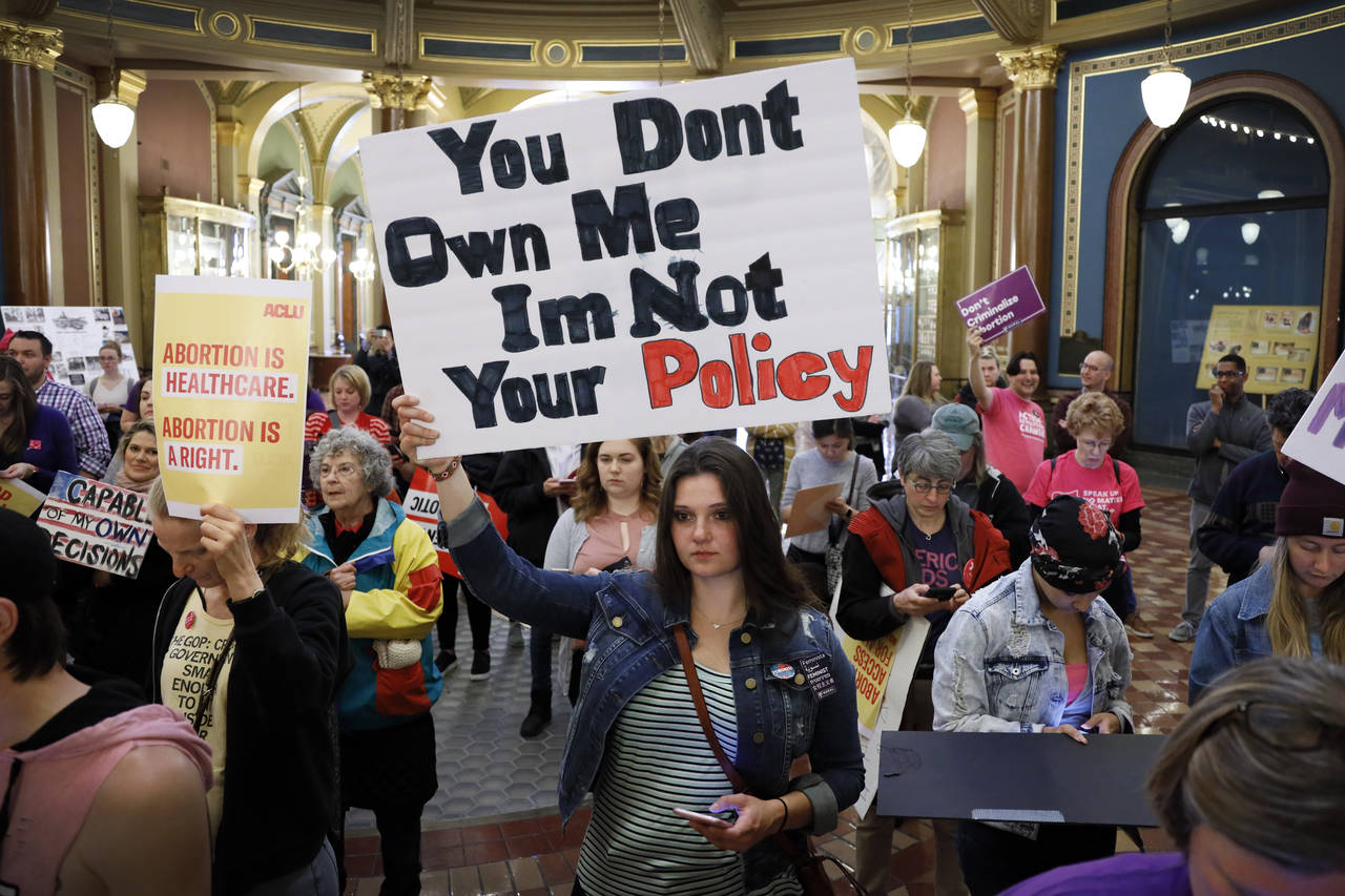 FILE - Marissa Messinger, of Lake View, Iowa, center, holds a sign during a rally to protest recent...