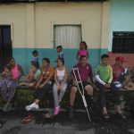 
              Venezuelan migrant Jesus Gonzalez, with a single crutch, sits with his family who are part of a migrant caravan that have stopped to rest in Huixtla, Chiapas state, Mexico, Wednesday, June 8, 2022. The 53-year-old man is alternating between crutches and a wheelchair pushed by relatives and friends as the family continues northward to the U.S.-Mexico border. They were the last migrants to reach Huixtla on Tuesday. (AP Photo/Marco Ugarte)
            