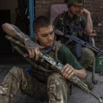 
              A security member of a medical rescue team cleans his weapon in the Donetsk oblast region, eastern Ukraine, Saturday, June 4, 2022. (AP Photo/Bernat Armangue)
            