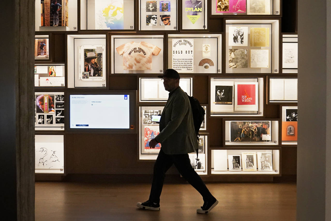 FILE - A man walks past a portion of the archive wall at the Bob Dylan Center, Thursday, May 5, 202...