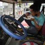 
              Passenger jeepney driver, Jet Marty dela Cruz, eats lunch inside his vehicle to save fuel instead of heading home as he takes a break at a gasoline station in Quezon City, Philippines on Monday, June 20, 2022. Around the world, drivers are looking at numbers on the gas pump and rethinking their habits and finances. (AP Photo/Aaron Favila)
            