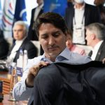 
              Canada's Prime Minister Justin Trudeau hangs his coat on the back of his chair as he waits for the start of a lunch with the Group of Seven leaders at the Schloss Elmau hotel in Elmau, Germany, Monday, June 27, 2022, during the annual G7 summit. Joining the Group of Seven are guest country leaders and heads of international organizations. (AP Photo/Susan Walsh, Pool)
            