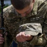 
              An Ukrainian serviceman mourns during the a funeral of Army Col. Oleksander Makhachek in Zhytomyr, Ukraine, Friday, June 3, 2022. According to combat comrades Makhachek was killed fighting Russian forces when a shell landed in his position on May 30. (AP Photo/Natacha Pisarenko)
            