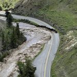 This aerial photo provided by the National Park Service shows a washed out road at North Entrance Road, of Yellowstone National Park in Gardiner, Mont., on June 13, 2022. Flooding caused by heavy rains over the weekend caused road and bridge damage in Yellowstone National Park, leading park officials to close all the entrances through at least Wednesday. Gardiner, a town just north of the park, was isolated, with water covering the road north of the town and a mudslide blocking the road to the south. (Doug Kraus/National Park Service via AP)
