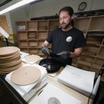 Ricky Riehl inspects finished vinyl records for physical flaws before they are packaged at the United Record Pressing facility Thursday, June 23, 2022, in Nashville, Tenn. (AP Photo/Mark Humphrey)