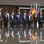 
              U.S. President Joe Biden, front fourth right, waves as he poses with G7 leaders and Outreach guests for an official group photo at Castle Elmau in Kruen, near Garmisch-Partenkirchen, Germany, on Monday, June 27, 2022. The Group of Seven leading economic powers are meeting in Germany for their annual gathering Sunday through Tuesday. (AP Photo/Markus Schreiber)
            