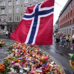 
              A Norwegian national flag waves over flowers and rainbow flags are placed at the scene of a shooting in central of Oslo, Norway, Sunday, June 26, 2022. Norwegian police say they are investigating an overnight shooting in Oslo that killed two people and injured more than a dozen as a case of possible terrorism. In a news conference Saturday, police officials said the man arrested after the shooting was a Norwegian citizen of Iranian origin who was previously known to police but not for major crimes. (AP Photo/Sergei Grits)
            