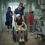 
              A hospital nurse pushes a wheelchair carrying a woman wounded by the Russian deadly rocket attack at a shopping centre in a city hospital in Kremenchuk in Poltava region, Ukraine, Tuesday, June 28, 2022.(AP Photo/Efrem Lukatsky)
            