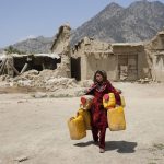 
              Afghan girl carries canisters in front of destroyed homes after an earthquake in Gayan district in Paktika province, Afghanistan, Sunday, June 26, 2022. A powerful earthquake struck a rugged, mountainous region of eastern Afghanistan early Wednesday, flattening stone and mud-brick homes in the country's deadliest quake in two decades, the state-run news agency reported. (AP Photo/Ebrahim Nooroozi)
            