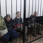 
              Two British citizens Aiden Aslin, left, and Shaun Pinner, right, and Moroccan Saaudun Brahim, center, sit behind bars in a courtroom in Donetsk, in the territory which is under the Government of the Donetsk People's Republic control, eastern Ukraine, Thursday, June 9, 2022. The two British citizens and a Moroccan have been sentenced to death by pro-Moscow rebels in eastern Ukraine for fighting on Ukraine's side. The three men fought alongside Ukrainian troops and surrendered to Russian forces weeks ago. (AP Photo)
            