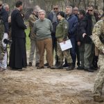 
              FILE - U.N. Secretary-General Antonio Guterres, center, stands on the side of a mass grave in Bucha, on the outskirts of Kyiv, Ukraine, Thursday, April 28, 2022. Police are investigating the killings of more than 12,000 Ukrainians nationwide in the war Russia is waging, the national police chief said Monday. In the Kyiv region near Bucha, authorities showed several victims whose hands were tied behind their backs. (AP Photo/Efrem Lukatsky, File)
            