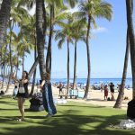 Two people take pictures on Waikiki Beach, Thursday, June, 23, 2022 in Honolulu. In a major expansion of gun rights after a series of mass shootings, the Supreme Court said Thursday that Americans have a right to carry firearms in public for self-defense.