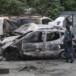 
              A Donetsk People Republic Emergency Situations Ministry employee walks at the scene of burned vehicles after the shelling in the Petrovsky district of Donetsk, on the territory which is under the Government of the Donetsk People's Republic control, eastern Ukraine, Sunday, June 5, 2022. The Russian State news agency TASS said five civilians were killed and 20 were injured Saturday as a result of multiple explosions close to the city of Donetsk. (AP Photo)
            