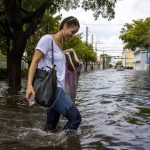 
              A pedestrian moves through floodwater on Southwest Second Street in the Little Havana neighborhood of Miami, Saturday, June 4, 2022. (Daniel A. Varela/Miami Herald via AP)
            