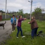 
              Nila Zelinska, center, is about to embrace her neighbor as she arrives to her home that was destroyed during attacks, in Potashnya, on the  outskirts of Kyiv, Ukraine, Tuesday, May 31, 2022. (AP Photo/Natacha Pisarenko)
            