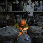 
              A staff member works at the Yuet Tung China Works, Hong Kong's last remaining hand-painted porcelain factory, in Hong Kong, Wednesday, June 8, 2022. The traditional technique of painting “guangcai,” or Canton porcelain is a fading art in this modern metropolis, as fewer young people are willing to put in the time and effort required to master the craft or to work at the factory full-time. (AP Photo/Kin Cheung)
            