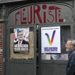 
              A man walks past election posters reading "Melenchon Prime Minister" for the alliance of leftist parties cobbled together by hard-left leader Jean-Luc Melenchon, Friday, June 10, 2022 in Lille, northern France. French voters were choosing lawmakers in a parliamentary election Sunday, June 12, 2022 as President Emmanuel Macron seeks to secure his majority while under growing threat from a leftist coalition. (AP Photo/Michel Spingler, File)
            