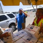 
              Volunteers begin to hand out 12-liter boxes of emergency drinking water to residents in need after a broken water main left the majority of Ector County without clean running water Tuesday, June 14, 2022 in Odessa, Texas. (Eli Hartman/Odessa American via AP)
            