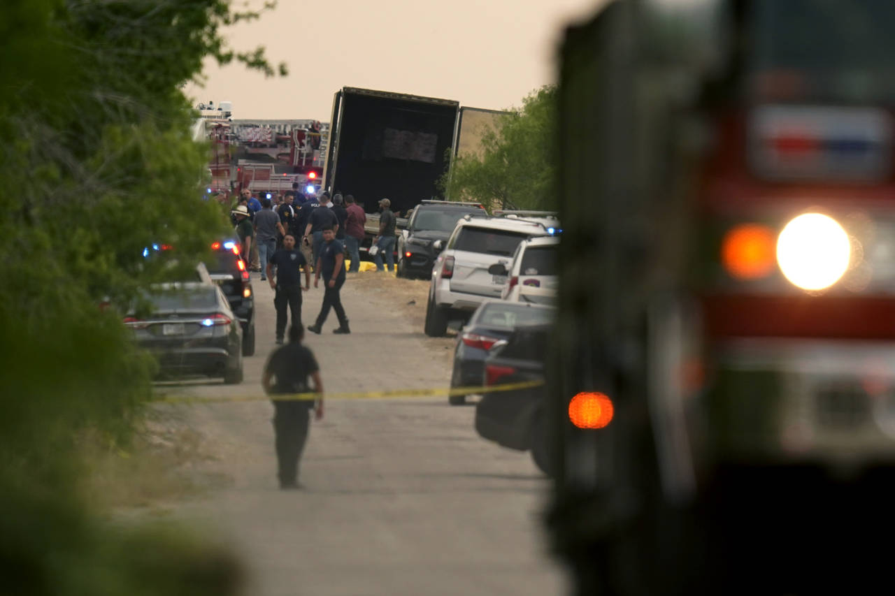 Body bags lie at the scene where a tractor trailer with multiple dead bodies was discovered, Monday...
