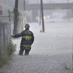 
              St. Louis firefighters checks on a car stalled out in chest-deep water flood water on Goodfellow Boulevard during a thunderstorm on Thursday, July 28, 2022, in St, Louis, Mo. (Carson, dcarson/St. Louis Post-Dispatch via AP)
            