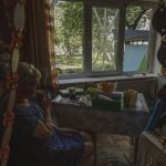 
              Resident Olena smokes her cigarette after her kitchen's windows broke in the aftermath of a rocket attack at a residential area, in Kramatorsk, eastern Ukraine, Tuesday, July 19, 2022. (AP Photo/Nariman El-Mofty)
            